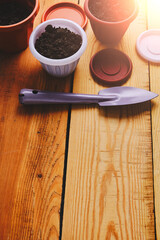 Flower pots and decorative gardening spatula on a wooden background.