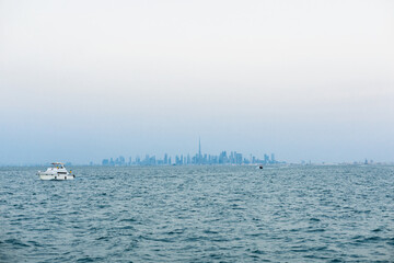 Pleasure boat against the background of skyscrapers and overlooking the Burj Khalifa on a cloudy day