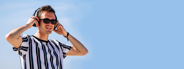 young man with headphones relaxing on the beach