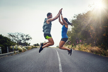 We did it and we did it together. Shot of a young attractive couple training for a marathon outdoors.