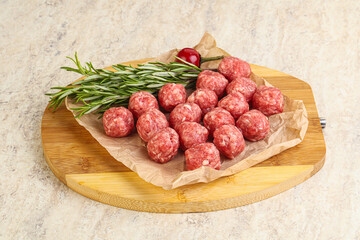 Raw uncooked beef meatballs served rosemary