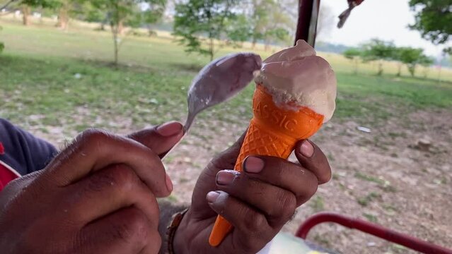 Close up male staff hand careful preparing ice snowy softy from vanilla ice cream cart in outdoor.