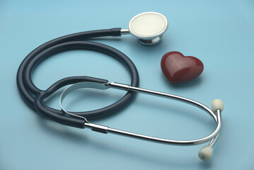 A heart or love object with a stethoscope on a blue background.heart health, health insurance concept, World heart day, world health day, doctor day, world hypertension day