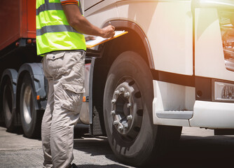 Auto Mechanic is Checking the Truck's Safety Maintenance Checklist. Lorry Fixing. Truck Inspection Safety of Semi Truck Wheels Tires. Auto Repair Service Shop. 		