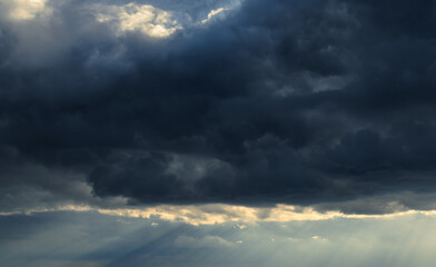 Naklejka na ściany i meble beautiful dramatic sky and sunlight, dark silhouette of clouds as background