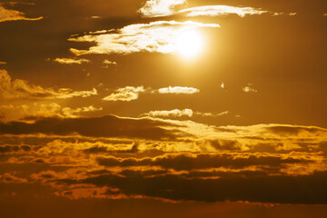 beautiful sunset sky, bright sunlight and dark silhouette of clouds as background