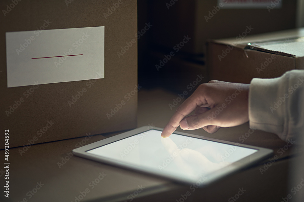 Poster There to help handle business more efficiently. Closeup shot of an unidentifiable delivery man using a digital tablet.