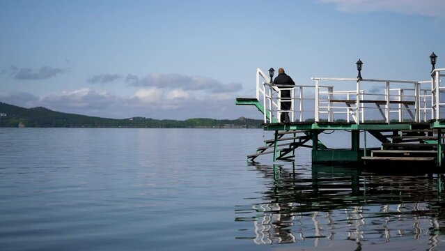Fisherman on the pier on the lake Auliekol (Borovoe, Kazakhstan)