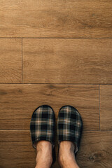 Male feet wearing plaid slippers in bathroom