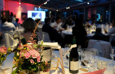 Evening event with flowers and wine bottles on the tables