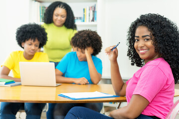Pretty african american computer science student with group of coding students
