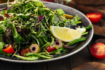 Green mediterranean salad with pine nuts and sun-dried tomatoes