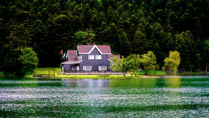 Lake house on the shore of Cennet Gol (Paradise Lake), Bolu. Reflected on water. House by the lake. Country side and farm field. © Akin Ozcan