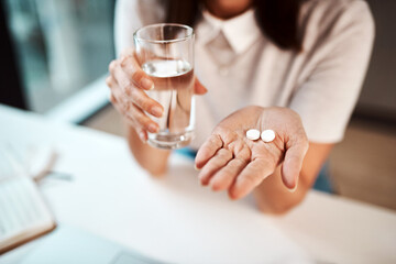 These will combat my symptoms. Closeup shot of an unrecognisable businesswoman holding a glass of water and medication in an office.