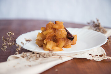 Caramelized apple dessert on wooden table. Baked or roast apple with cinnamon.