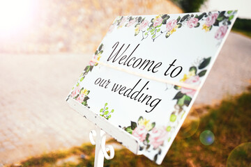 Wedding concept photo. Welcome to our wedding message on a floral board at the entrance of the...