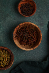 Spices. Various Indian Spices on black stone table. Spice and herbs on slate background. Assortment of Seasonings, condiments. Cooking ingredients, flavor. Cardamom, saffron, anise, curry, turmeric.