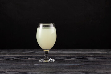 Rejuvelac in drinking glass. Healthy fermented drink. Natural probiotic made by soaking grain or...