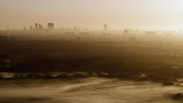 Establishing Cinematic Aerial Drone shot of Foggy Sunrise in the dunes of Kijkduin with The Hague in the Background