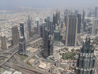 Fototapeta na wymiar Dubai, UAE- March 31 2022: Daylight view of the skyline of a megacity with massive buildings and highways. Dubai Metropolis as seen from the Burj Khalifa.