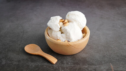 cold coconut milk ice cream summer dessert, bowl on wooden floor
