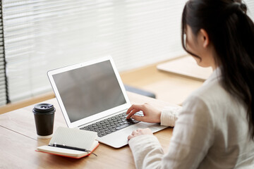 Fototapeta premium コワーキングスペースで仕事をするアジア人女性 