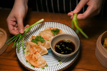 Close-up image, Female preparing her special Chinese fried dumplings in the kitchen.