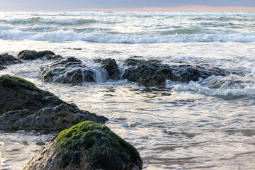 Cap Blanc-Nez sea waves splashing with white foam against rocks, a colourful, rocky beach with a beautiful sea pattern, background wallpaper. Cap Blanc-Nez, France. High quality photo