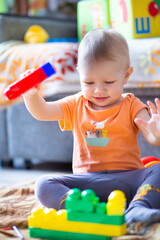 A child collects a rainbow-colored constructor on a blurred background.