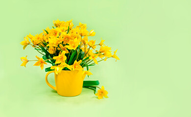 Yellow forest tulips in a yellow ceramic vase on a green background. Place for text. Basis for a postcard