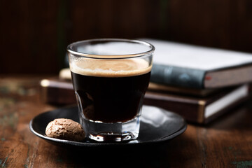 Coffee in glass cup on dark wooden background. Close up.