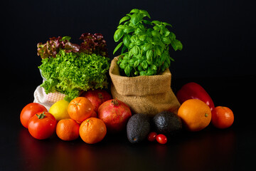 Fresh fruit composition with herbs on black background.