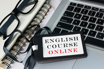 English course online text written on black name tag placed on a laptop.