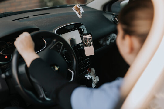 Woman sitting in car and using map on phone