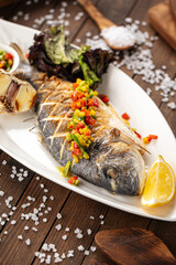 Appetizing grilled fish on the wooden background