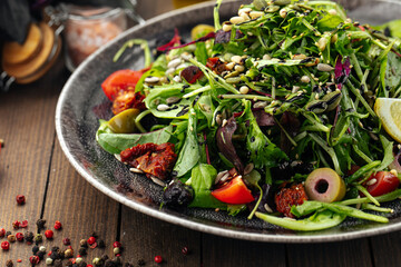 Green mediterranean salad with pine nuts and sun-dried tomatoes