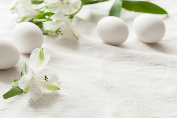 Fototapeta na wymiar White background with white easter eggs and white spring flowers, rustic background