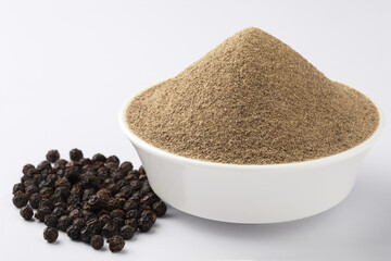 Indian spices - black pepper powder,Black pepper corns scattered on white background and Black...