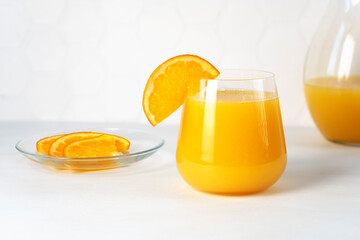 Glass of orange juice with fruit slice. Citrus drink. Healthy beverage.