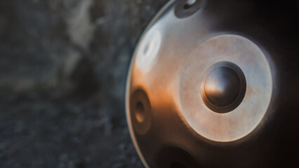 A close-up view of a musical instrument called a handpan, also known as a hang or pantam. Copy space, shallow depth of field.