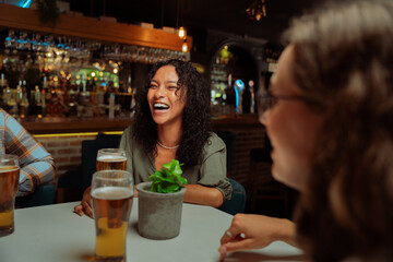 diverse group of friends out for dinner in restaurant laughing 