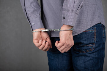 Men's hands behind their backs in handcuffs