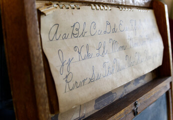 Closeup shot of an old paper with alphabet letters on a wooden background