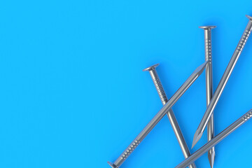 Metal nails on blue background. Building equipment. Tool for repair, renovation. Top view. Copy space. 3d render
