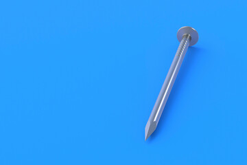 Obraz premium One metal nail on blue background. Building equipment. Tool for repair, renovation. Copy space. 3d render