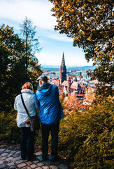 Vertical back view of a senior couple admiring the breathtaking  Freiburg cityscape