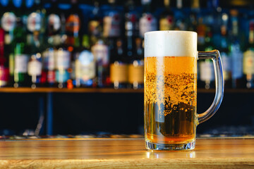 Fresh cold beer in glass on bar background
