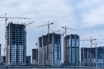 Fototapeta na wymiar Construction site of multi-storey houses and building cranes