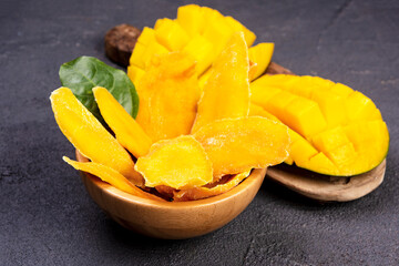 fresh and Dried sliced Mango. Dried mango in wooden bowl and fresh mango fruit. Superfood, vegetarian food concept.