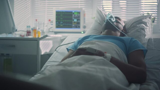 Ill patient breathe oxygen mask in emergency room. Modern hospital ward interior